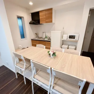 a kitchen and dining room with a wooden table and chairs at \u30a2\u30f3\u30c9\u30b9\u30c6\u30a4\u91ce\u65b92\u4e01\u76ee in Tokyo