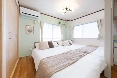a bedroom with two beds and two windows at Sakura Inn Tokyo Skytree in Tokyo