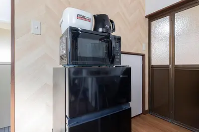 a microwave sitting on top of a refrigerator at The North Ikebukuro Hotel in Tokyo