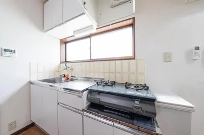 a kitchen with a stove and a sink and a window at The North Ikebukuro Hotel in Tokyo