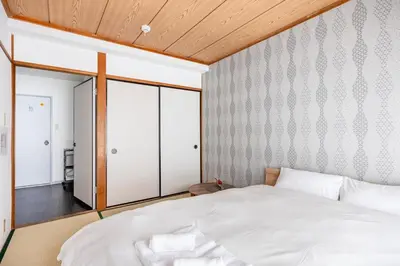 a bedroom with a white bed and a large window at BAi\u304a\u82b1\u8336\u5c4b1\u4e01\u76ee\u30d1\u30fc\u30eb\u30cf\u30a4\u30c4202 in Tokyo