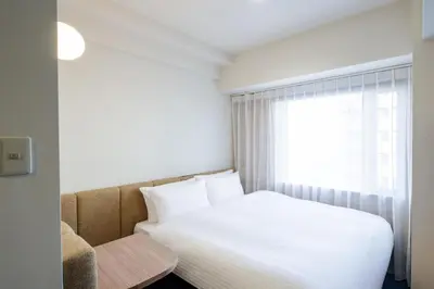 a bedroom with a white bed and a window at HOTEL AMANEK Asakusa Sakurabashi in Tokyo