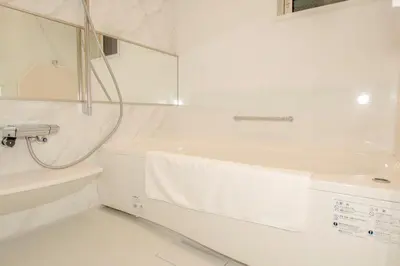 a white bathroom with a tub and a sink at \u6c60\u888b\u672c\u753a202 in Tokyo