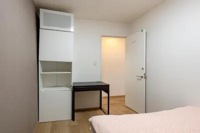 a bedroom with a bed and a desk and a closet at \u6771\u4e2d\u91ce in Tokyo