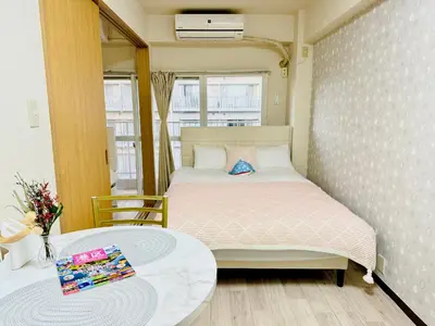 a small bedroom with a bed and a table at \u9ad8\u8f2a\u30fc703 in Tokyo
