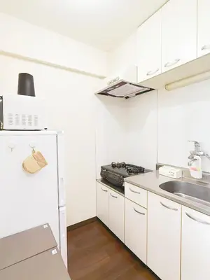 a white kitchen with a stove and a sink at \u9ad8\u8f2a\u30fc703 in Tokyo