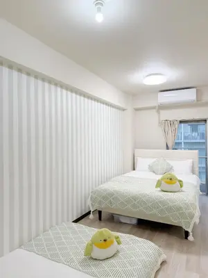 two beds in a bedroom with white walls at \u9ad8\u8f2a\u30fc703 in Tokyo