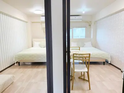 a room with two beds and a table and a bed at \u9ad8\u8f2a\u30fc703 in Tokyo