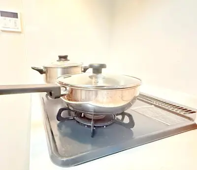 two pots sitting on top of a stove at \u6c60\u888b\u672c\u753a301 in Tokyo