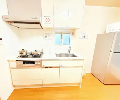 a white kitchen with a sink and a refrigerator at \u6c60\u888b\u672c\u753a302 in Tokyo
