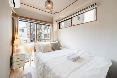 a bedroom with a white bed and a window at #32 -\u670d\u90e8\u30d3\u30eb\u6771\u6c60\u888b- Condo in Tokyo