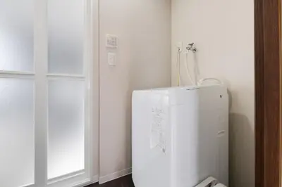 a white refrigerator in a corner of a room at #32 -\u670d\u90e8\u30d3\u30eb\u6771\u6c60\u888b- Condo in Tokyo