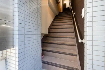a staircase in a building with a person walking up the stairs at #32 -\u670d\u90e8\u30d3\u30eb\u6771\u6c60\u888b- Condo in Tokyo