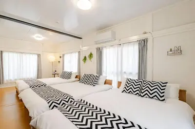 three beds in a room with white walls and windows at Higashi tateishi Kodate HTI1 in Tokyo