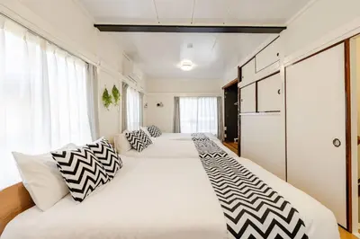 two beds in a bedroom with white and black pillows at Higashi tateishi Kodate HTI1 in Tokyo