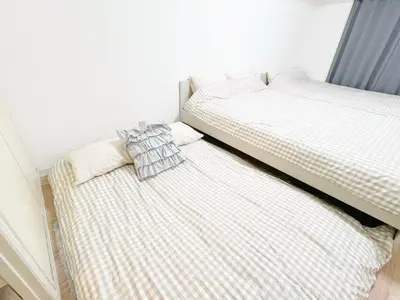 two beds sitting next to each other in a bedroom at Ikebukuro home 18 in Tokyo