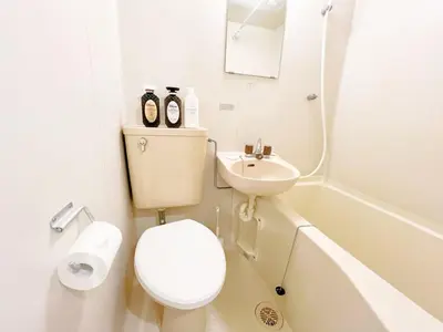 a white bathroom with a toilet and a sink at Ikebukuro home 18 in Tokyo
