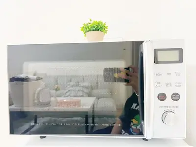 a person taking a picture of a microwave at Ikebukuro home 18 in Tokyo