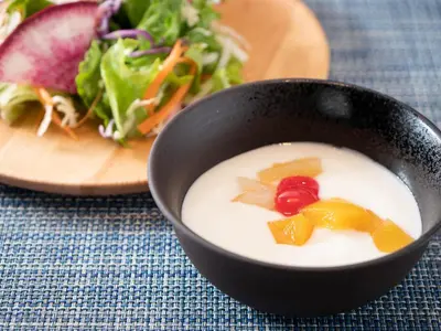 a bowl of soup next to a plate of salad at Super Hotel Shinbashi-Karasumoriguchi in Tokyo