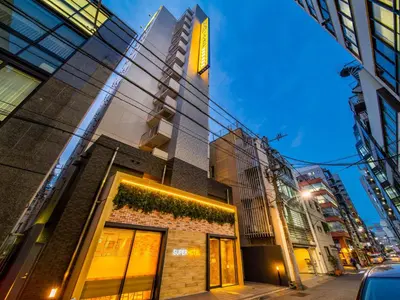 a tall building on a city street at night at Super Hotel Shinbashi-Karasumoriguchi in Tokyo
