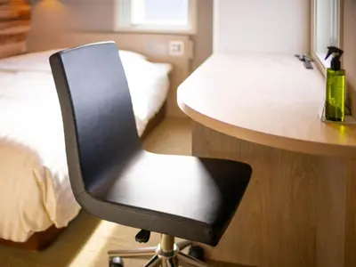 a black chair sitting at a desk in a bedroom at Super Hotel Shinbashi-Karasumoriguchi in Tokyo