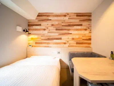 a bedroom with a bed and a wooden wall at Super Hotel Shinbashi-Karasumoriguchi in Tokyo