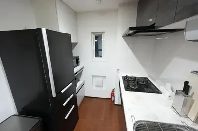 a kitchen with a black and white stove top oven at 100 INN Suite in Tokyo