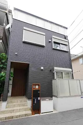 a black house with a door and a window at 100 INN Suite in Tokyo