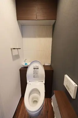 a small bathroom with a toilet with the lid up at 100 INN Suite in Tokyo