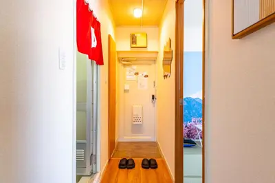 a hallway with two pairs of shoes sitting on a bench at SakuraFlat in Tokyo