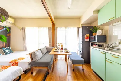 a small apartment kitchen and living room with a couch and a table at SakuraFlat in Tokyo