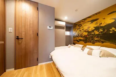 two beds in a room with a painting on the wall at Vacation house rental Matsu kaze tei Tokyo in Tokyo