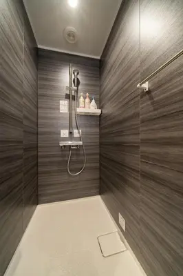a shower in a bathroom with wooden walls at Vacation house rental Matsu kaze tei Tokyo in Tokyo