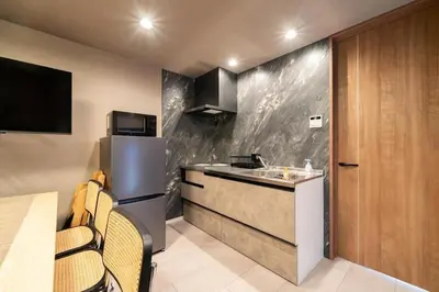 a small kitchen with a sink and a refrigerator at Vacation house rental Matsu kaze tei Tokyo in Tokyo