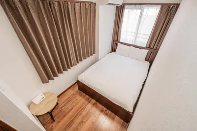 a small bed in a small room with a window at Tokyo Stay House Hirai in Tokyo