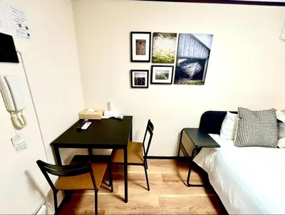 a bedroom with a desk and a bed and a table at Nishi Shinjuku City House \u897f\u65b0\u5bbf\u30b7\u30c6\u30a3\u30fc\u30cf\u30a6\u30b9 - \u6771\u4eac\u89b3\u5149\u306b\u4fbf\u5229\u306a\u65b0\u5bbf\u30b9\u30c6\u30a4 in Tokyo