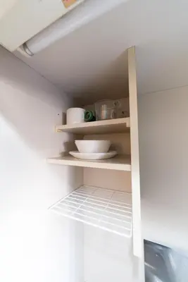 a shelf in a kitchen with some dishes on it at Nishi Shinjuku City House \u897f\u65b0\u5bbf\u30b7\u30c6\u30a3\u30fc\u30cf\u30a6\u30b9 - \u6771\u4eac\u89b3\u5149\u306b\u4fbf\u5229\u306a\u65b0\u5bbf\u30b9\u30c6\u30a4 in Tokyo