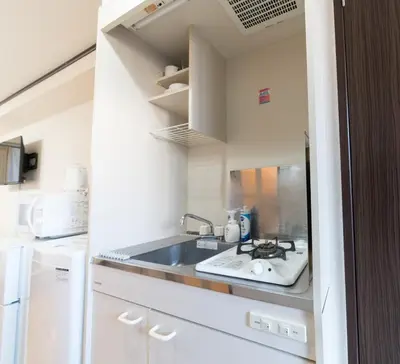 a kitchen with a sink and a refrigerator at Nishi Shinjuku City House \u897f\u65b0\u5bbf\u30b7\u30c6\u30a3\u30fc\u30cf\u30a6\u30b9 - \u6771\u4eac\u89b3\u5149\u306b\u4fbf\u5229\u306a\u65b0\u5bbf\u30b9\u30c6\u30a4 in Tokyo