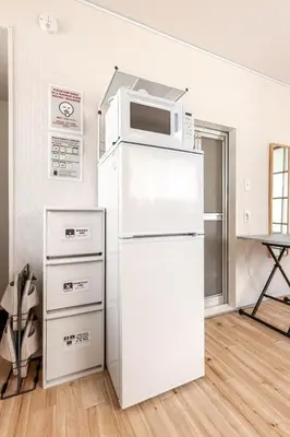 a white refrigerator with a microwave on top of it at tkm\u5317\u5c0f\u5ca91\u4e01\u76ee101 in Tokyo