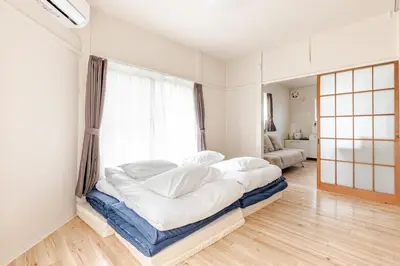 a bedroom with a large bed in a room with a window at tkm\u5317\u5c0f\u5ca91\u4e01\u76ee103 in Tokyo