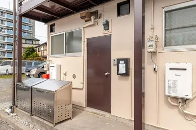 a front door of a building with a pay phone at tkm\u5317\u5c0f\u5ca91\u4e01\u76ee103 in Tokyo