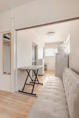 a living room with a table and a couch at tkm\u5317\u5c0f\u5ca91\u4e01\u76ee103 in Tokyo