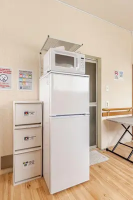 a microwave on top of a refrigerator in a room at tkm\u5317\u5c0f\u5ca91\u4e01\u76ee201 in Tokyo