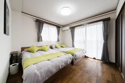 a bedroom with two beds and two windows at Apartment hotel 3 minutes walk from JR Asagaya station Ideal base for exploring Tokyo HOTEL CtrlD ASAGAYA in Tokyo