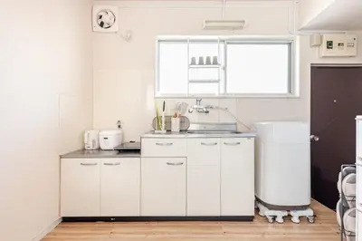a white kitchen with a sink and a window at tkm\u5317\u5c0f\u5ca91\u4e01\u76ee203 in Tokyo