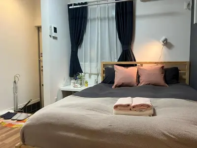 a bedroom with a large bed with two towels on it at 102 \u5c71\u624b\u7ebf\u8fd1\u4e0a\u91ce\u4e00\u7ad9\u6e29\u99a8\u65b0\u516c\u5bd3 in Tokyo