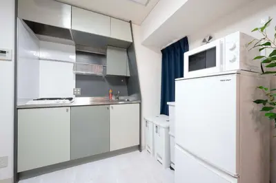 a kitchen with white cabinets and a refrigerator at 8Minutes Walk to IkebukuroStation, CentralTokyo and VeryConvenient Max5People in Tokyo
