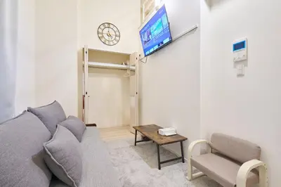 a living room with a couch and a clock on the wall at N 5min to waseda sta designer condo high security free wifi in Tokyo