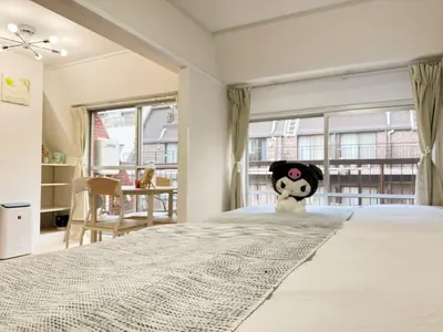a bedroom with a large bed with a panda toy on it at Minato Residence-Tokyo Tower-Daimon in Tokyo