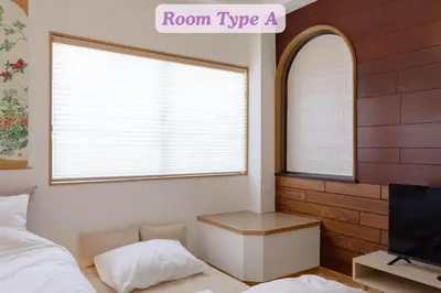 a bedroom with a bed and a window with a tv at Sakura Hotel Koiwa in Tokyo